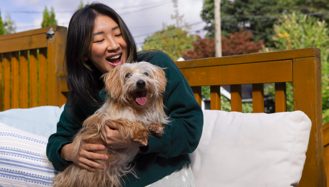 A pet owner plays with her dog on the patio